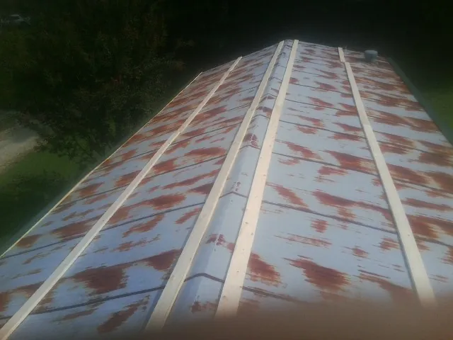 Rusted metal roof panels with new wood purlins before replacement — Storm Damage Roof Repair in Ronda by Roofing Brothers