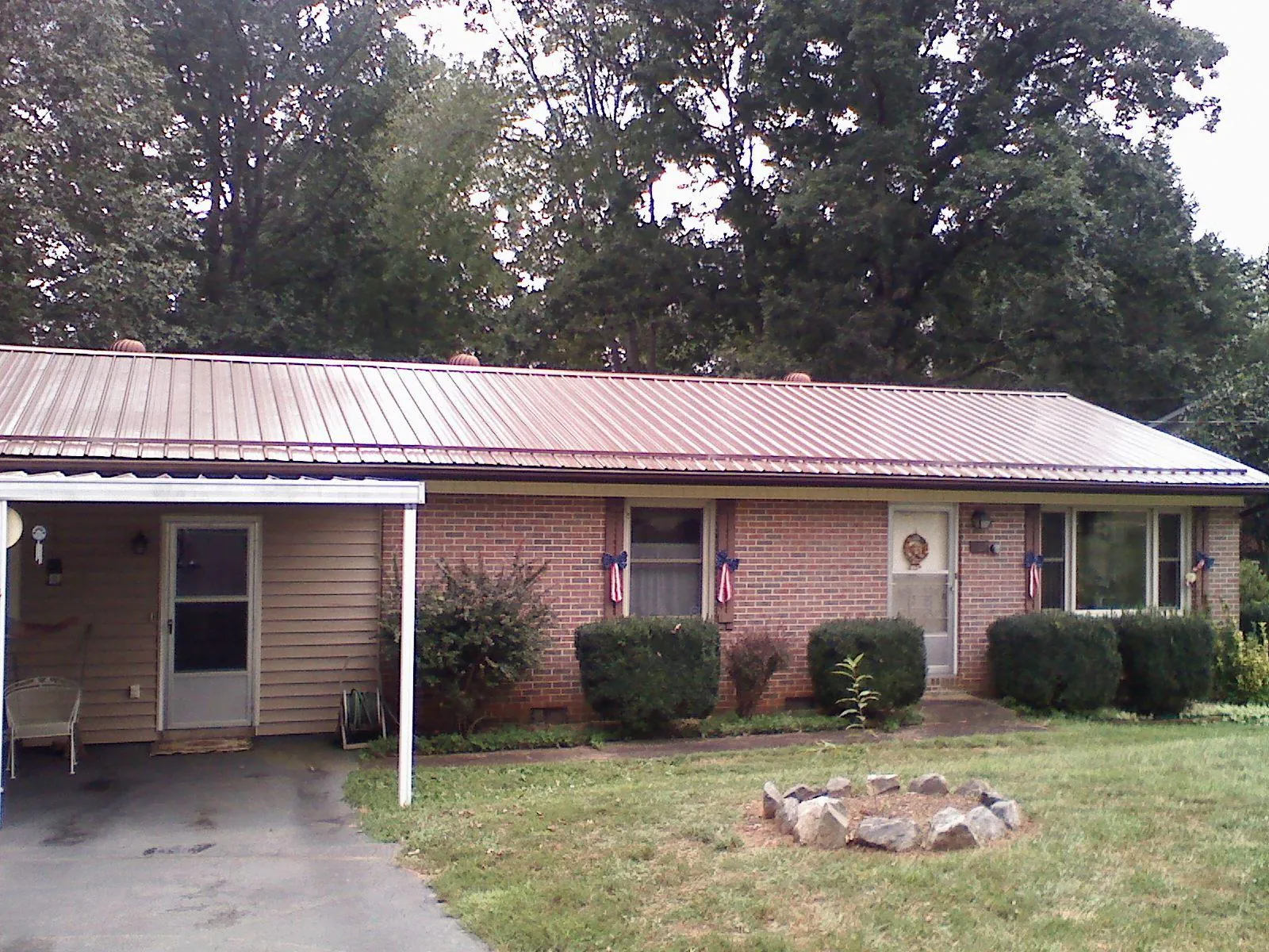 Bronze metal roof and carport on a brick ranch home — Roof Repair work by our crew in Ronda